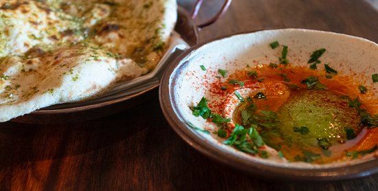 Zahav signature dishes Hummus with Laffa Bread, Pomegranate Lamb Shoulder, Salatim (vegetable salads), Haloumi